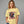 Woman wearing a yellow t-shirt with a graphic design and text 'Follow Your Dreams' on a gray background.