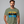 Man wearing a green t-shirt with 'Gone Fishing' graphic design on a gray background