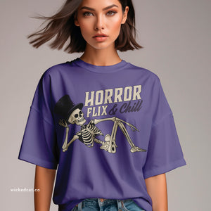 Person wearing a black t-shirt with 'Horror Flix & Chill Skeleton Halloween' design on a plain background