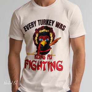 Person wearing a black t-shirt with 'Kung Fu Fighting Turkey 80s Music Funny' design on a plain background
