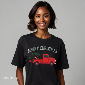 Woman wearing a black t-shirt with a red truck and 'Merry Christmas' design on a gray background