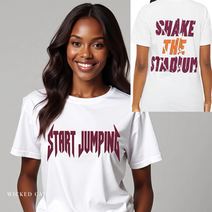 A woman wearing a white graphic T-shirt with the phrase 'START JUMPING' in a dark burgundy stylized font across the chest. A smaller inset shows the back of the same shirt with the phrase 'SHAKE THE STADIUM' in matching burgundy and orange lettering.