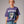 Person wearing a black t-shirt with 'Tequila Lovers Sugar Skull' design on a plain background