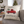 Christmas pillow with a red truck and a Charlie Brown Christmas Tree in the back.