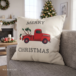 Christmas pillow with a red truck and a Charlie Brown Christmas Tree in the back.