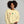 Woman wearing a beige sweatshirt with cocktail graphics on a gray background