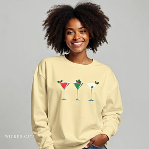 Woman wearing a beige sweatshirt with cocktail graphics on a gray background