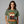 Woman wearing a green t-shirt with 'Hoppy Thanksgiving' design on a gray background