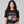 Person wearing a black t-shirt with 'Rainbows & Unicorns Funny' design on a plain background