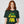 Person wearing a green t-shirt with yellow and green text on a plain background