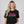 Person wearing a dark gray t-shirt with 'Magically Delicious Funny St. Patrick's Day' design on a plain background