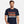 Person wearing a Aqua t-shirt with 'Whippet Good Devo 80's Music Funny' design on a plain background